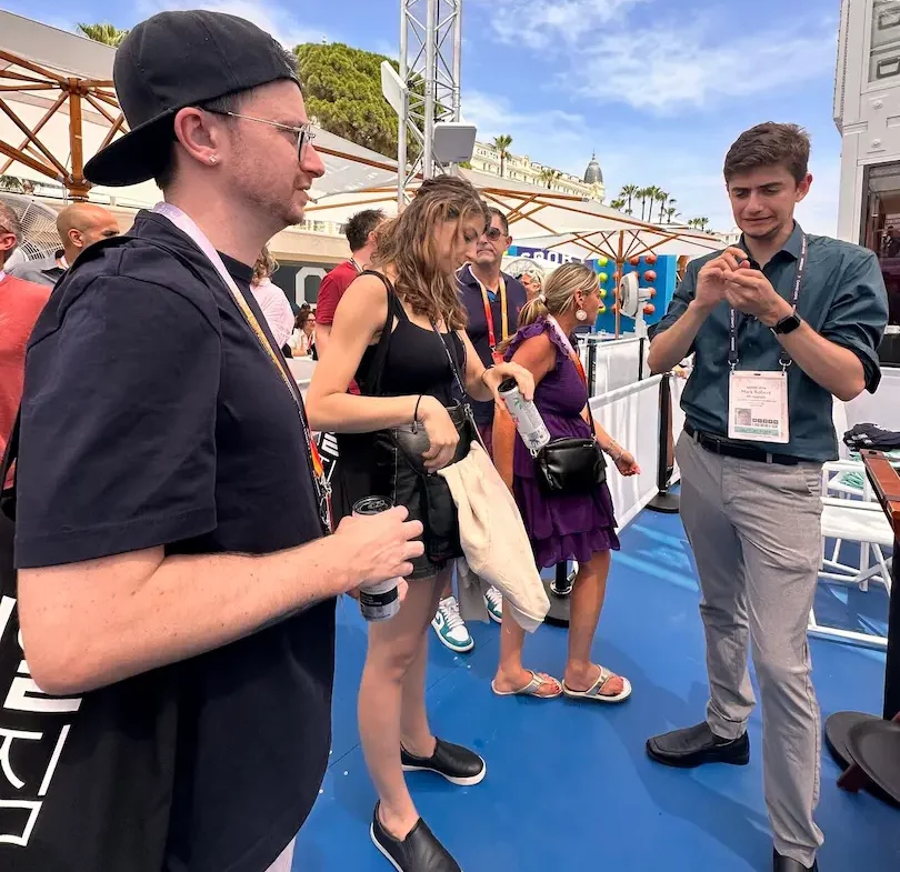 Patrick watches an ASL interpreter sign during a networking event on an outdoor terrace at the festival.