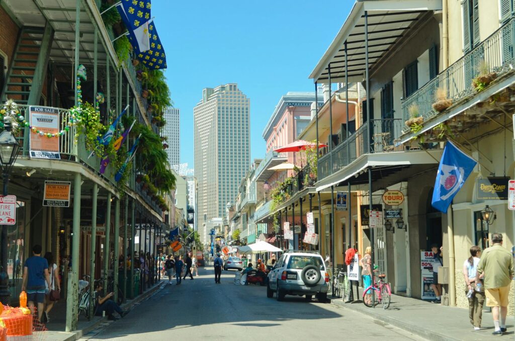 A French Quarter street in New Orleans lined with balconied townhouses and iron railings.