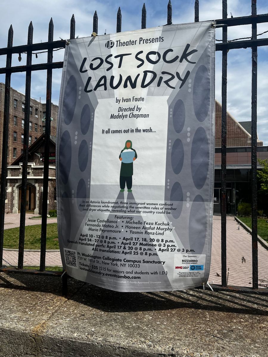 Outdoor poster for "Lost Sock Laundry" by Ivan Faute, featuring dates and actors’ names, on a fence with a church in the background.
